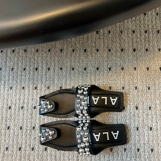 ALAIA FOLDED FLAT MULES WITH SPHERES ON BLACK CALFSKIN