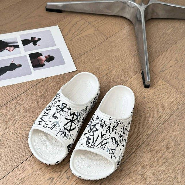 POOL GRAFFITI CROCS SLIDE SANDALS IN WHITE AND BLACK RUBBER