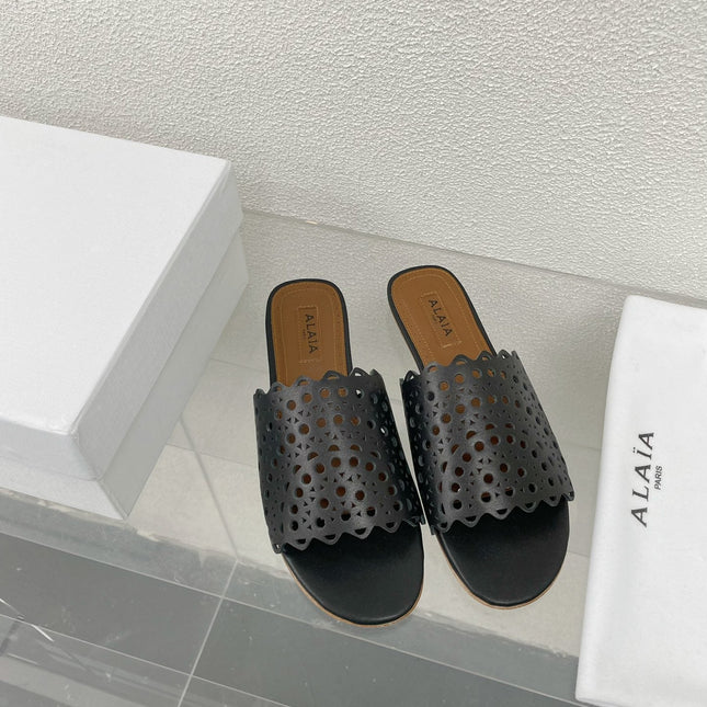 ALAIA VIENNE FLAT MULES IN BLACK LAMBSKIN